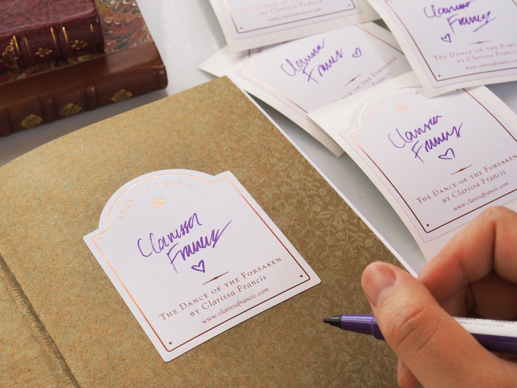 author signing bookplate in use with example stuck in book and signed with purple pen