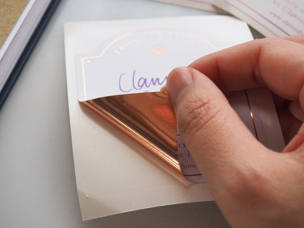 Peeling back sticker detail revealing foil underside