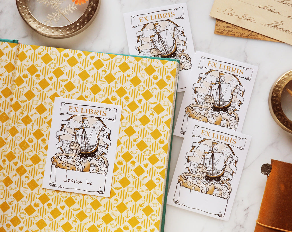 Crossing the Seas bookplate sticker stuck in a book with name written inside flatlay on a desk