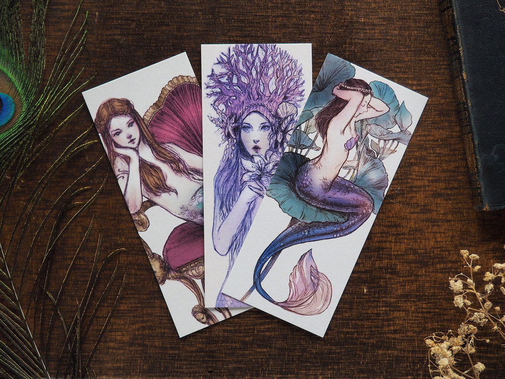 Set of 3 illustrated mermaid bookmarks flaylay on a desk