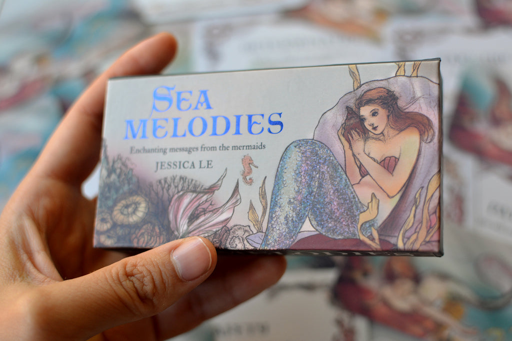 Hand holding Sea Melodies Mini Inspiration Cards box packaging showing metallic blue text and holographic tail foiling