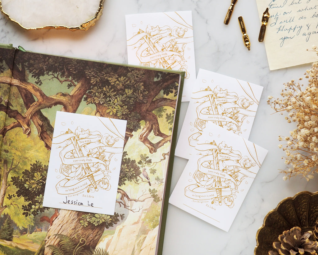 Shadowsteel illustrated bookplate sticker stuck in a book with name written inside desk flatlay