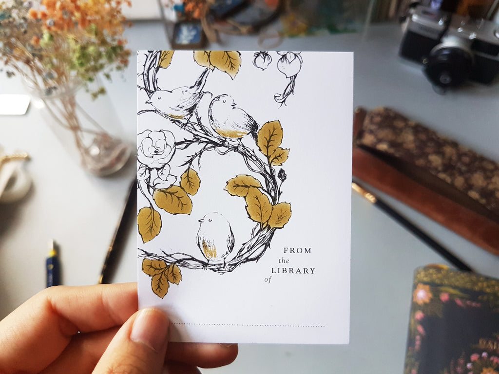 Hand holding bird ex libris bookplates