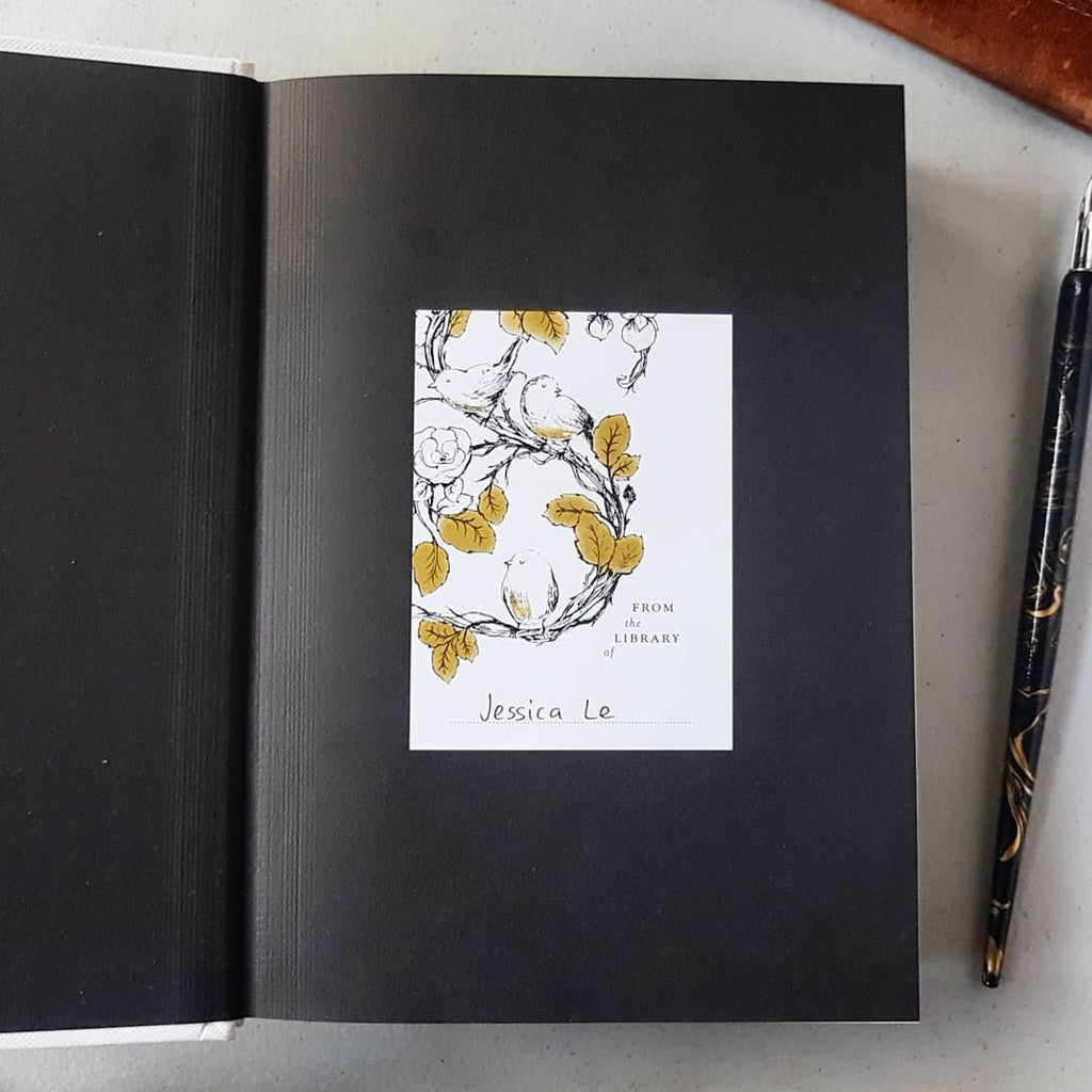 Bird bookplate stuck in a book with name written inside