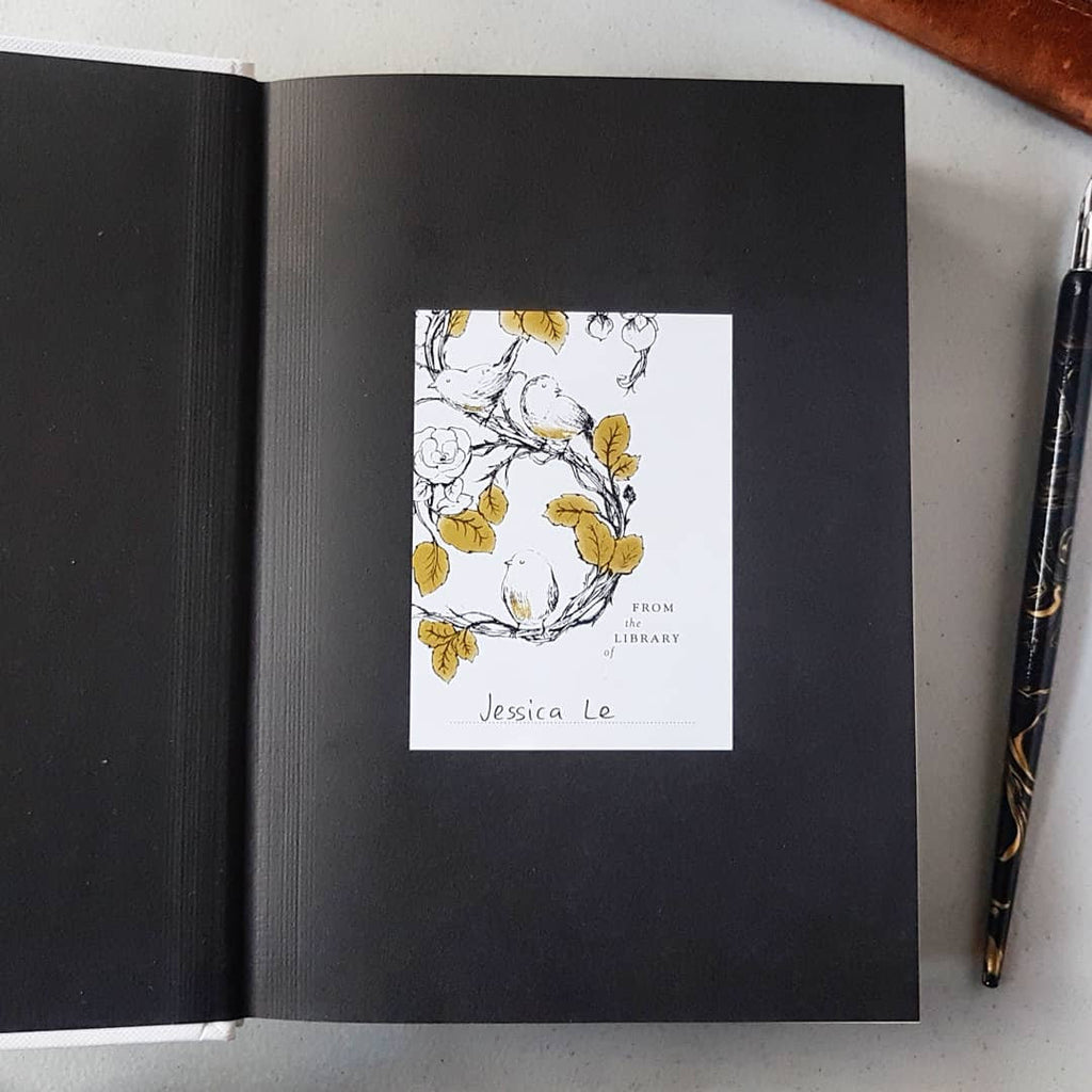 Bird bookplate stuck in a book with name written inside